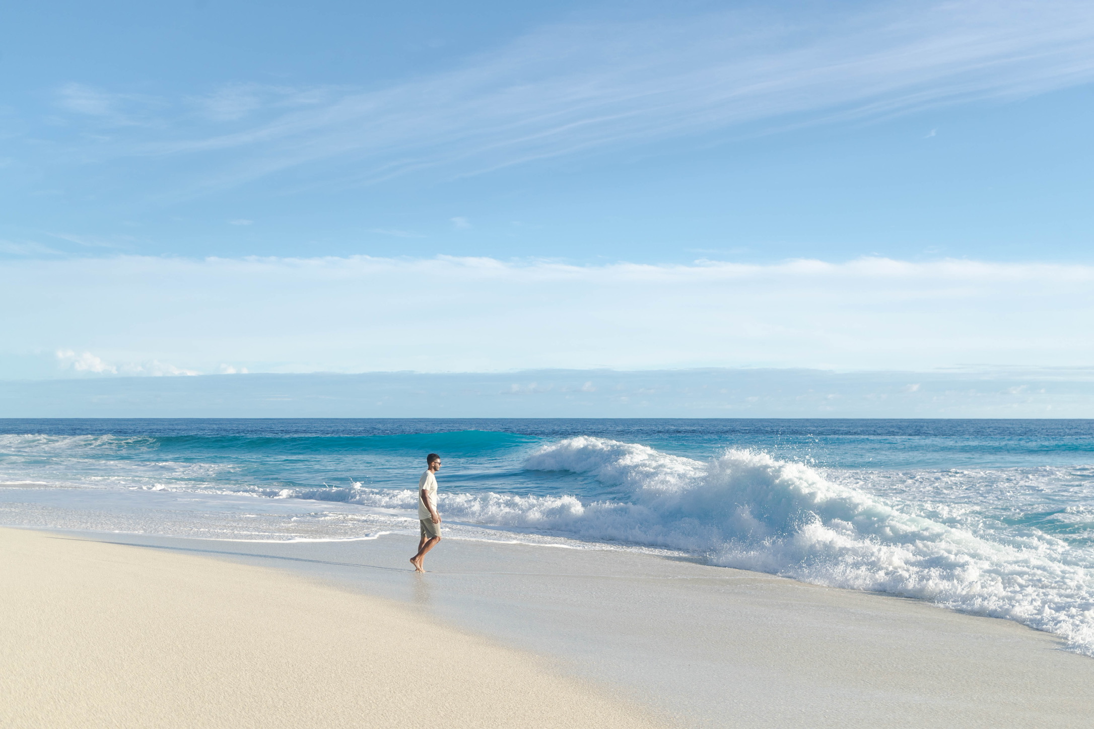 Beginner surfer riding a clean wave with a wide smile and reef & palm backdrop in Fuvahmulah